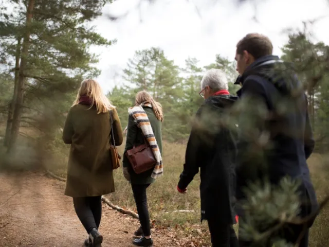 Une famille en balade en forêt en France discute du décès de leur proche.
