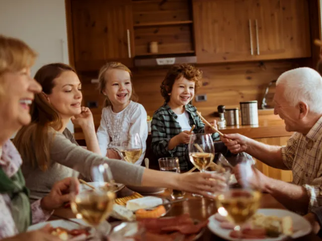 Une famille de plusieurs générations discutent d'héritage en France autour d'un repas.