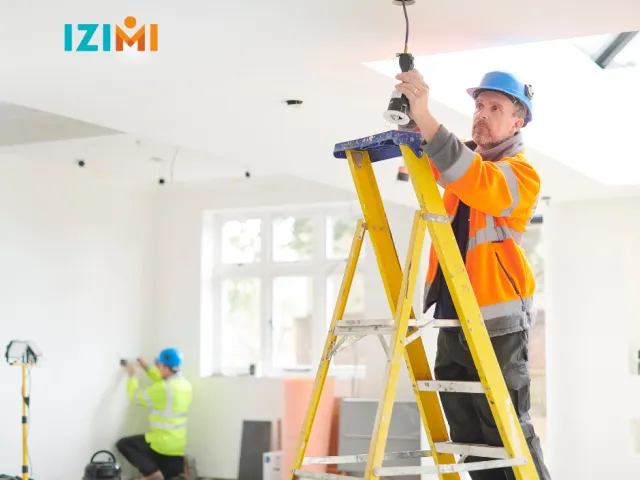 Deux entrepreneurs effectuent des travaux dans une maison en France.